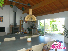 Séjour lumineux à Lacanau avec grande baie vitrée et poêle à bois