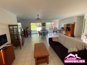 Séjour lumineux avec baies vitrées, vue sur la piscine et la terrasse