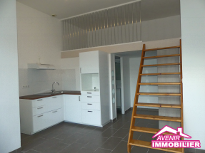 Pièce de vie lumineuse de l’appartement T1 à louer à Le Porge, avec espace salon et cuisine ouverte.